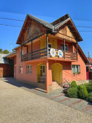 a large orange house with a balcony on it at Casa Mariei in Vama Buzăului