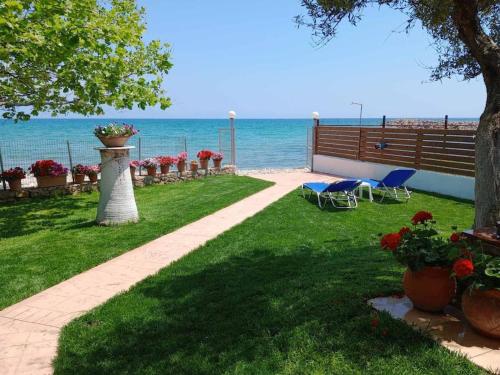 a garden with a pathway leading to the beach at Agios Andreas Beach Villas in Áyios Andréas Messinias