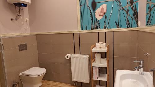 a bathroom with a toilet and a sink at Apartamenty Stara Piekarnia in Sławatycze