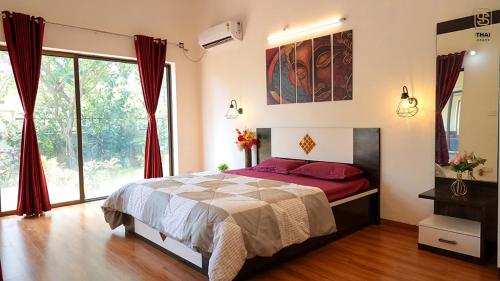 a bedroom with a bed and a large window at Thai Stays Villa in Shenwa