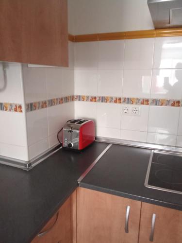 a kitchen with a red toaster on the counter at Apartamento Sevilla AUTENTICA in Dos Hermanas