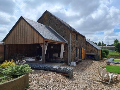a large brick building with a patio in front of it at Stable Cottage at Le Prieuré in Mantilly