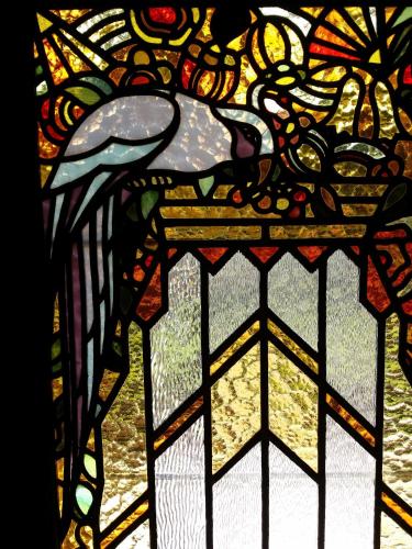 a stained glass window with a bird on it at Le Castel Guesthouse in Bayeux