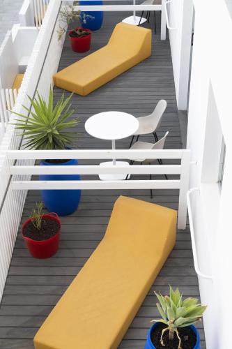 an office with yellow benches and potted plants at Buendía Corralejo Nohotel in Corralejo