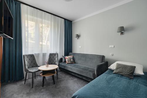 a bedroom with a bed and a couch and a table at Rewita Waplewo in Maróz