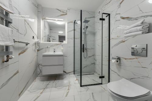 a white bathroom with a shower and a toilet at Rewita Waplewo in Maróz