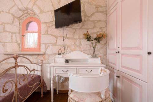 a bathroom with a chair and a tv on the wall at Aresti Mountain Resort in Agios Leon