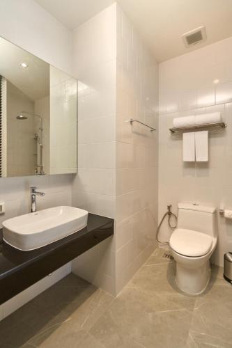 a white bathroom with a sink and a toilet at Red Door Samsen Hotel, Bangkok in Bangkok