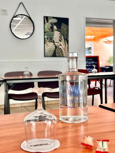 a bottle of water sitting on a wooden table at The Originals City, Hôtel Le Pavillon, Béziers Est in Béziers