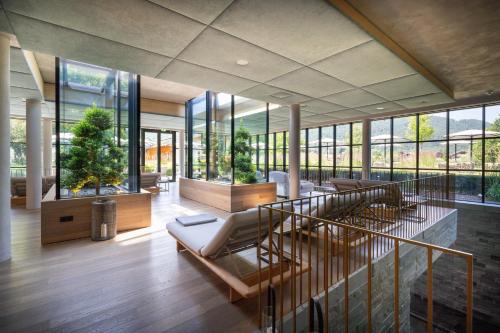 a living room with a staircase and windows at Parkhotel Egerner Höfe in Rottach-Egern