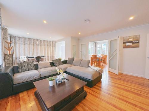 a living room with a couch and a table at Charming Spacious 4 BR house in Lower Hutt