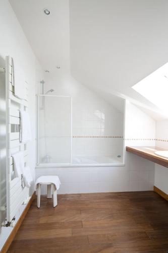 La salle de bains blanche est pourvue d'une douche et d'un banc. dans l'établissement LA RECREATION _ Ancienne école de 1850 rénovée en maison d'hôtes, à Missillac