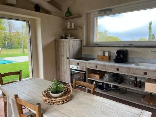 a kitchen with a table and a large window at Agriturismo Il Caio dimora di campagna in Bagnoregio
