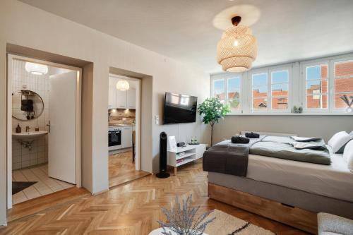 a bedroom with a large bed and a television at Boho Design Studio - Historic City Center with Free Parking & AirCon by HERO HOMES in Graz