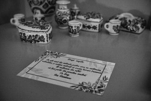 a card sitting on a table with vases and cups at Rai Romanesc in Sălişte