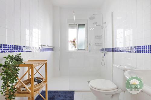 Un baño blanco con inodoro y ducha. en Casa La Maroma - Spacious and quiet family home, en Alcaucín