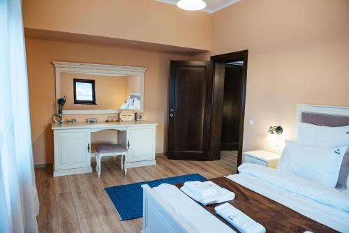 a bedroom with a bed and a desk with a mirror at Rai Romanesc in Sălişte