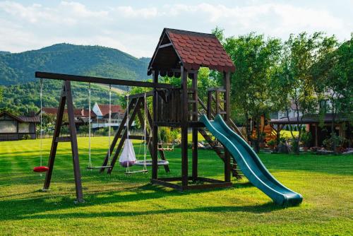 a playground with a slide in a park at Rai Romanesc in Sălişte