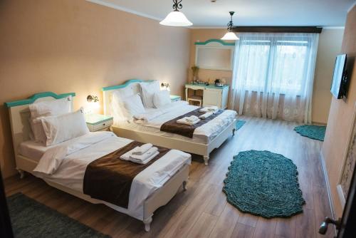 a bedroom with two beds and a blue rug at Rai Romanesc in Sălişte
