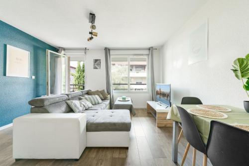 un salon avec un canapé et une table dans l'établissement T3 parking gratuit, balcon et résidence sécurisée, à Toulouse