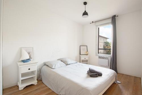 une chambre blanche avec un lit et une fenêtre dans l'établissement T3 parking gratuit, balcon et résidence sécurisée, à Toulouse