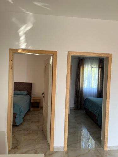 Un dormitorio con dos camas y un espejo. en Apartman Vaso, en Prijevor