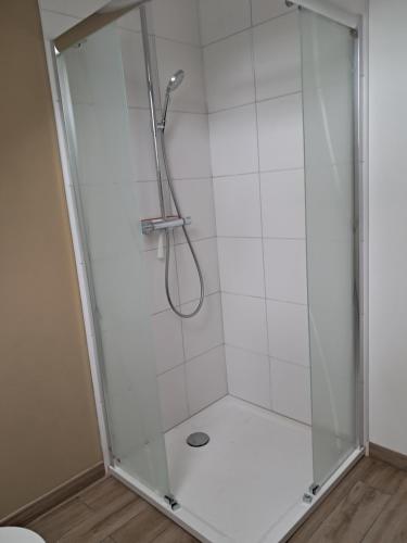 a shower with a glass door in a bathroom at Stable Cottage at Le Prieuré in Mantilly
