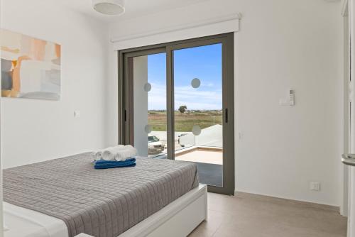 Un dormitorio con una cama y una puerta corrediza de vidrio. en Serenity Waves Villa 19, en Lárnaca