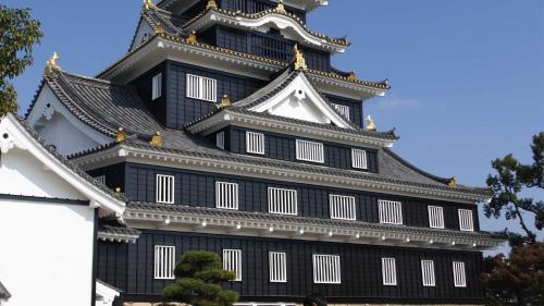 a black and white building with a tower at Toyoko Inn Okayama eki Nishi guchi Hiroba in Okayama