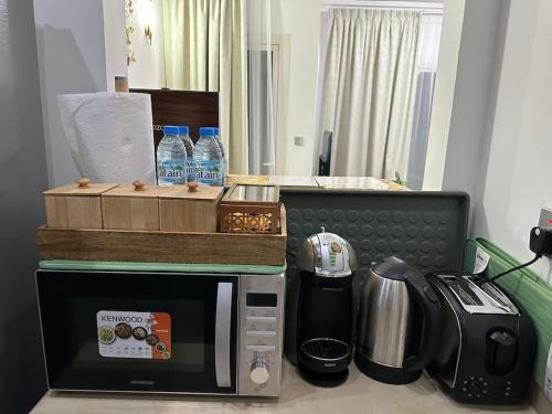 a kitchen with a microwave and a coffee maker and water bottles at Holiday Townhouse 889 in Ras al Khaimah