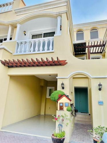 a large white house with a balcony and plants at Holiday Townhouse 889 in Ras al Khaimah