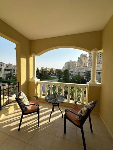 a balcony with two chairs and a table on a balcony at Holiday Townhouse 889 in Ras al Khaimah