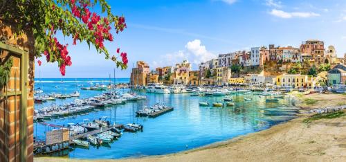 Un grupo de barcos atracados en un puerto con edificios. en La Rosa Dei Venti, en Castellammare del Golfo