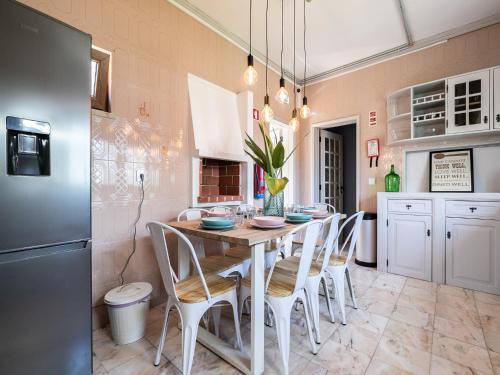 a kitchen with a table with chairs and a refrigerator at Walk in Hostel Faro Airport in Faro