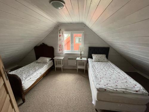 a room with two beds and a table and a window at Brzezina Resort - Wille in Żnin