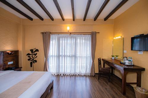 a bedroom with a bed and a desk and a window at Pokhara Boutique Hotel in Pokhara