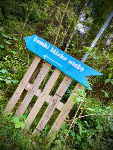 a blue sign sitting on top of a wooden bench at Domki Blisko Nieba I in Wisła