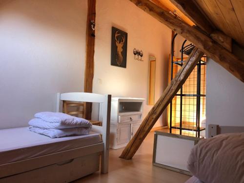 a attic room with a bed and a ladder at T2 Jausiers in Jausiers