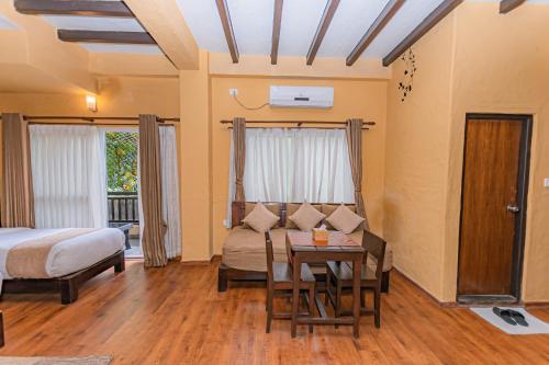 a bedroom with a bed and a table and a couch at Pokhara Boutique Hotel in Pokhara