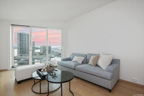 a living room with a couch and a table at Luxury 3 bedroom seaview apartment, ONS 2024 in Stavanger