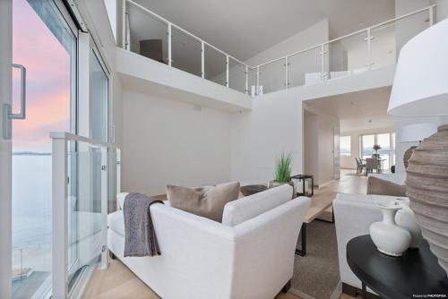 a living room with white furniture and a view of the ocean at Luxury 3 bedroom seaview apartment, ONS 2024 in Stavanger