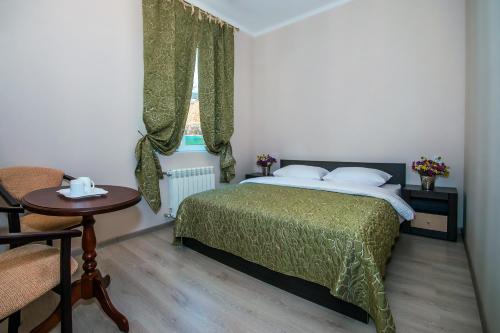 a bedroom with a bed and a window and a table at Mini Hotel Ryleev in Kharkiv