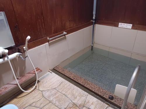 a bathroom with a shower with a glass wall at 一棟貸切コンパクトハウス 黒川温泉まで車で10分 TAO flow in Minamioguni