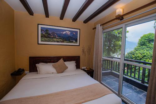 a bedroom with a bed and a large window at Pokhara Boutique Hotel in Pokhara