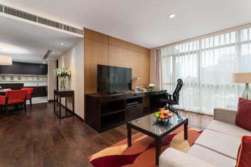 a living room with a couch and a television at Sathorn Vista, Bangkok - Marriott Executive Apartments in Bangkok