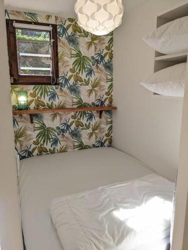 une petite chambre avec un lit et une fenêtre dans l'établissement Agréable studio dans résidence calme sous les pins, à Lacanau