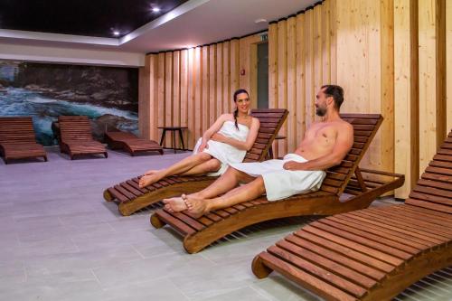 a man and a woman sitting on benches in a room at Hotel Slovakia in Trenčianske Teplice