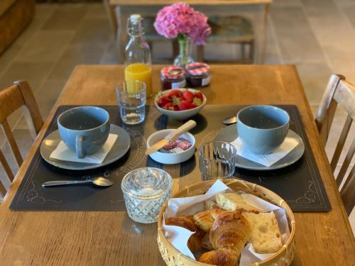 Perne, chambre d'hôtes à la campagne في Frossay: طاولة عليها إفطار من الكرواسون وأكواب القهوة