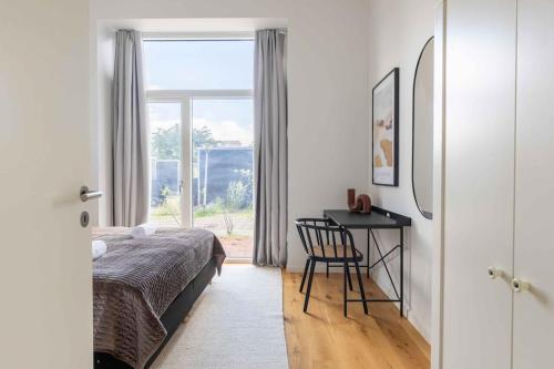 哥本哈根Step-Free Apartment for 8 People Near Amager Beach的一间卧室，配有一张床、一张书桌和一扇窗户