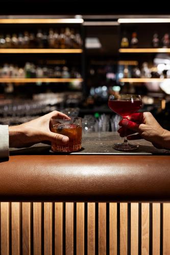 a couple of people holding drinks at a bar at Parkhotel Egerner Höfe in Rottach-Egern